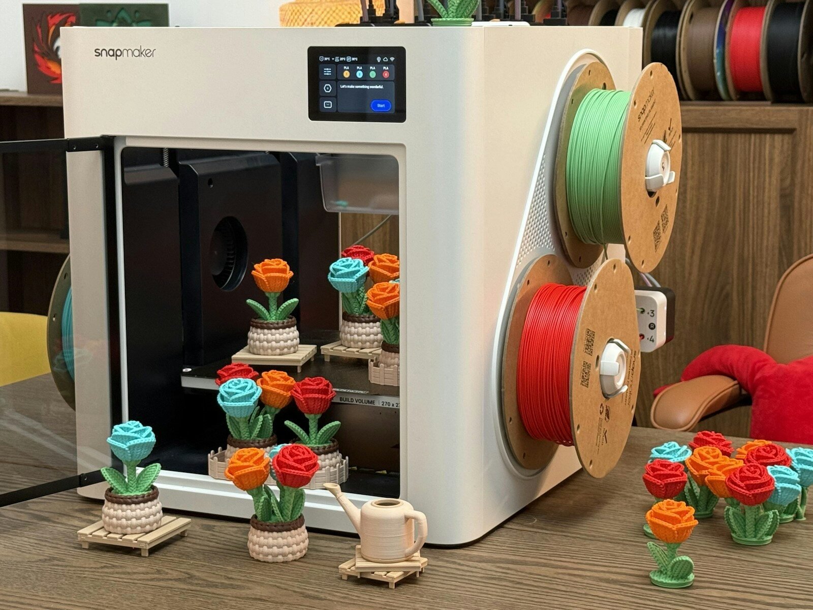 3D printer with colorful flower prints and spools
